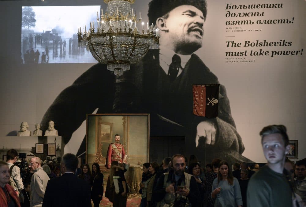 People gather by a portrait of the last Russian tsar Nicholas II and a huge image of the Soviet Union founder Vladimir Lenin during the opening of the exhibition entitled &quot;The Winter Palace and the Hermitage in 1917. History was made here&quot; at the State Hermitage Museum in Saint Petersburg on Oct. 25, 2017. (Olga Maltseva/AFP/Getty Images)