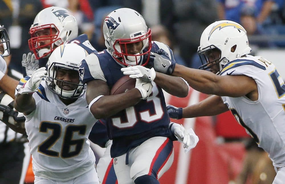 New England Patriots running back Dion Lewis carries the ball against Los Angeles Chargers cornerback Casey Hayward (26) and inside linebacker Hayes Pullard, right, during the second half of Sunday's game in Foxborough. (Michael Dwyer/AP)