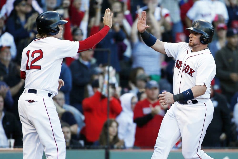 Boston Red Sox's Christian Vazquez and Brock Holt (12) celebrate after scoring on a two-run double by Rafael Devers during the fourth inning of a baseball game against the Houston Astros in Boston, Sunday, Oct. 1, 2017. (AP Photo/Michael Dwyer)