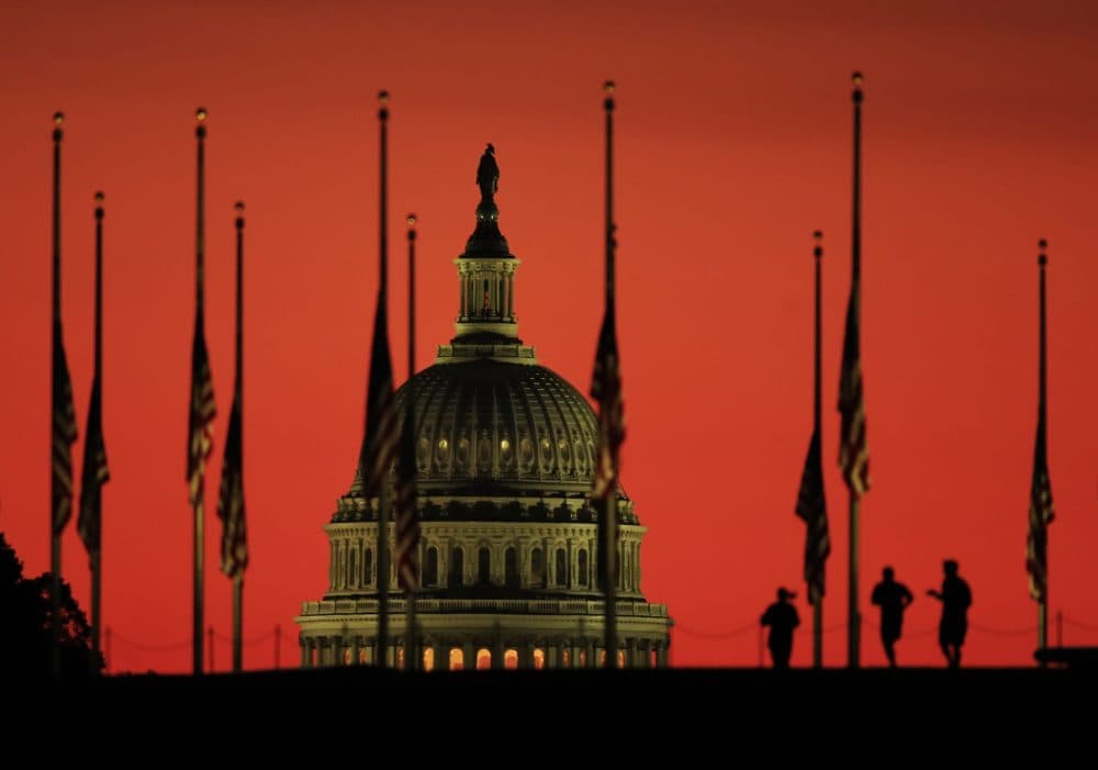 The U.S. Capitol dome backdrops flags at half-staff in honor of the victims killed in the Las Vegas shooting as the sun rises on Tuesday, Oct. 3, 2017, at the foot of the Washington Monument on the National Mall in Washington. (Manuel Balce Ceneta/AP)