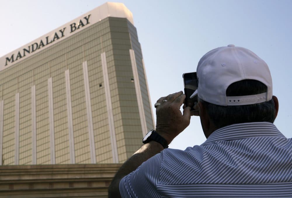A tourist takes a photo of the broken out windows at the Mandalay Bay hotel on Wednesday, Oct. 4, 2017, in Las Vegas. A gunman opened fire on an outdoor music concert on Sunday killing dozens and injuring hundreds, from the windows. (John Locher/AP)