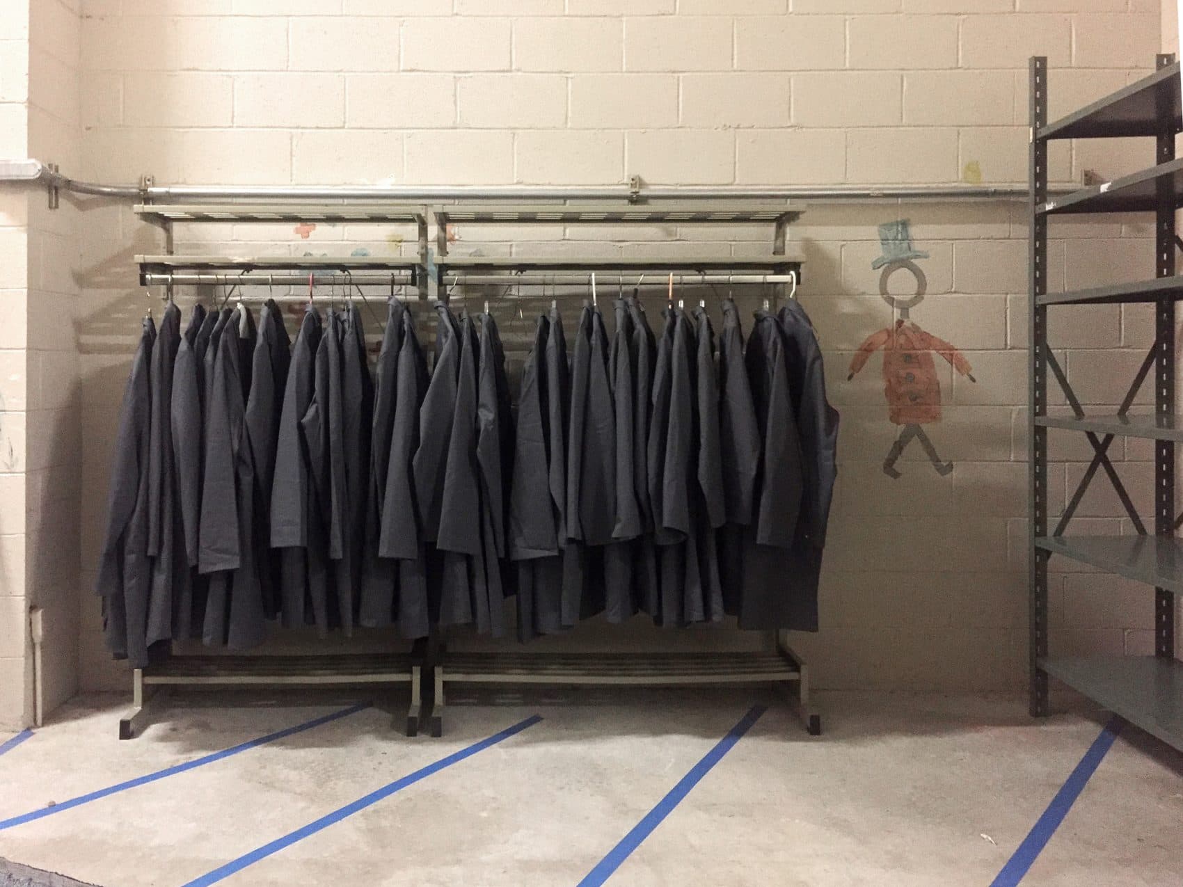 A rack holds gray lab coats, ready for the &quot;Waiting Rooms&quot; attendants to wear. (Courtesy Nathalie Pozzi/Museum of Science)