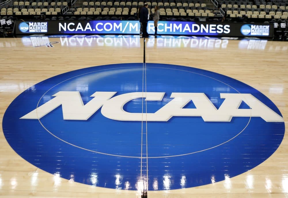 In this March 18, 2015 photo, the NCAA logo is at center court for the NCAA college basketball second and third round games.  The NCAA and 11 major athletic conferences announced Friday, Feb. 3, 2017,  they have agreed to pay $208.7 million to settle a federal class-action lawsuit filed by former college athletes who claimed the value of their scholarships was illegally capped.
(AP Photo/Keith Srakocic, File)