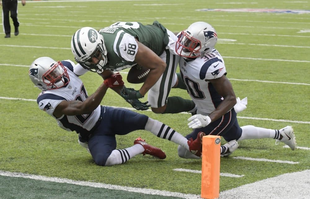 New York Jets tight end Austin Seferian-Jenkins (88) is tackled by New England Patriots' Malcolm Butler (21) and Duron Harmon (30) during the second half of an NFL football game, Sunday, Oct. 15, 2017, in East Rutherford, N.J. After further review the play was ruled a fumble into the end zone. (AP Photo/Bill Kostroun)