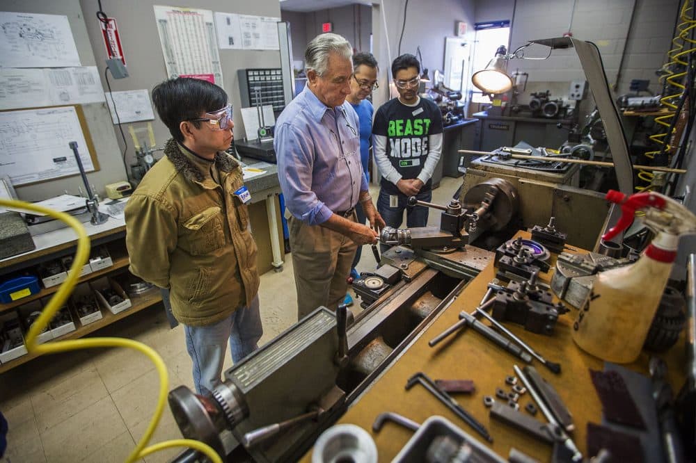 Cosmo Pasciuto shows students how to operate a lathe at the Center for Manufacturing Technology at Custom Machine in Woburn. (Jesse Costa/WBUR)
