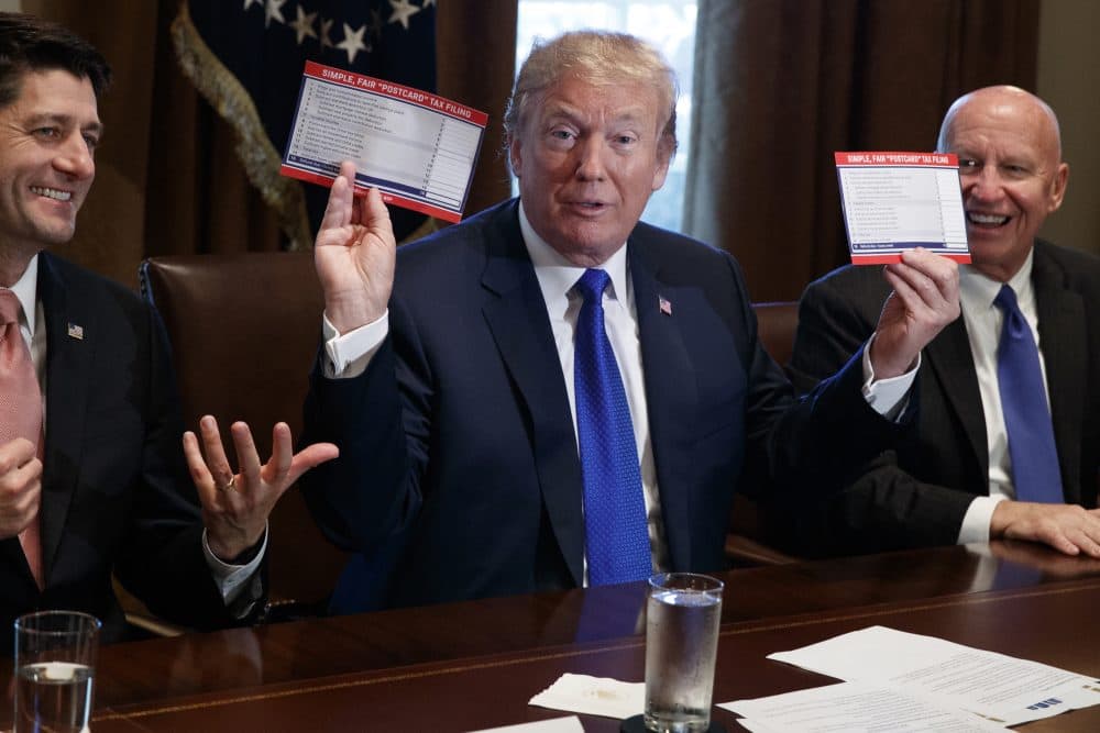President Trump holds an example of what a new tax form may look like during a meeting on tax policy with Republican lawmakers including House Speaker Paul Ryan of Wis., and Chairman of the House Ways and Means Committee Rep. Kevin Brady, R-Texas, right, in the Cabinet Room of the White House, Thursday, Nov. 2, 2017, in Washington. (Evan Vucci/AP)