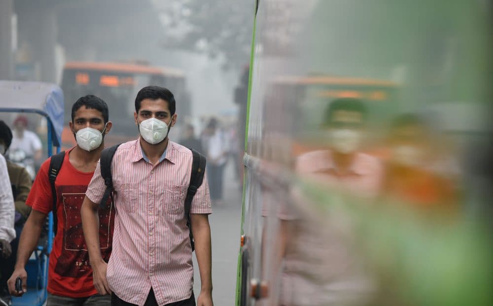 Indian commuters wear masks as they walk along a road amid heavy smog in New Delhi on Nov. 9, 2017. (Sajjad Hussain/AFP/Getty Images)
