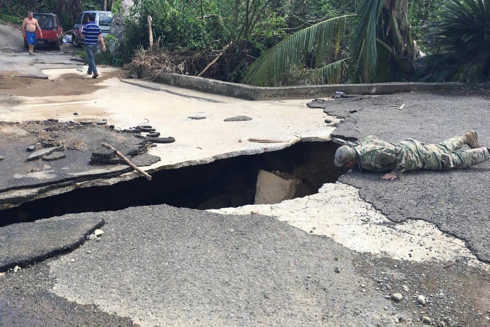 1st Lt. Erin Graham of the North Carolina National Guard inspects a washed out bridge in the small Puerto Rico community of Vallaja. (Jay Price/WUNC)