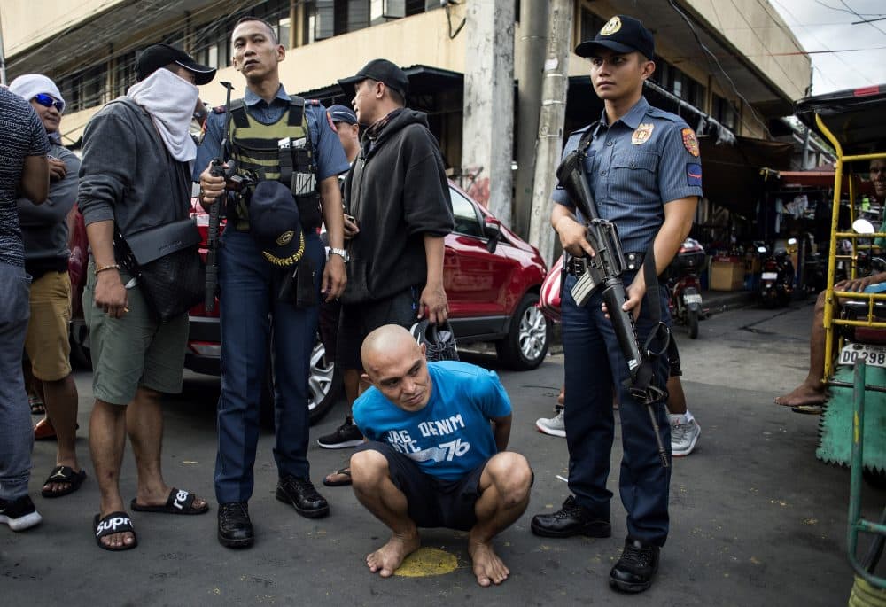 An alleged drug dealer is captured by police officers after a drug buy-bust operation on a slum area in Manila on Sept. 28, 2017. (Noel Celis/AFP/Getty Images)