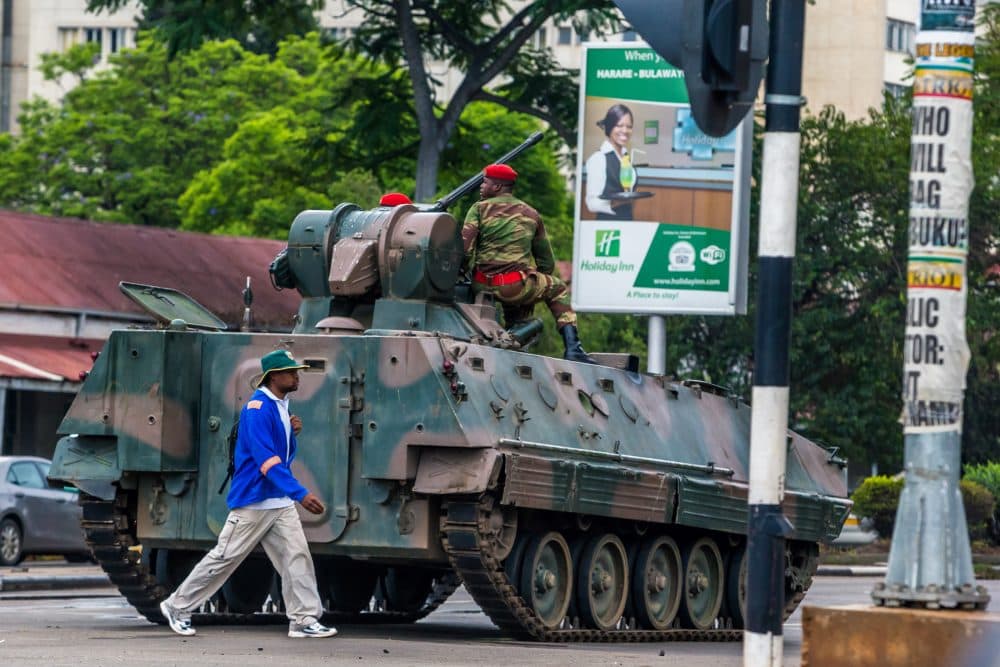 A man walks past an armoured personnel carrier that stations by an intersection as Zimbabwean soldiers regulate traffic in Harare on Nov. 15, 2017. Zimbabwe's military appeared to be in control of the country on Nov. 15 as generals denied staging a coup but used state television to vow to target &quot;criminals&quot; close to President Mugabe. (AFP/Getty Images)