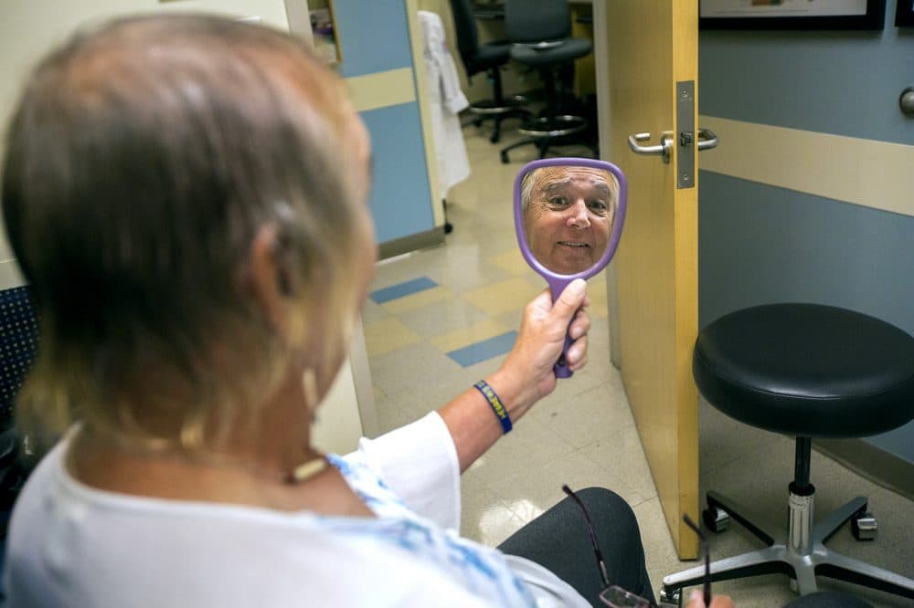 Tami Goodhue looks in a mirror during her appointment to review information about the facial feminization surgery she wishes to have done at Boston Medical Center. (Jesse Costa/WBUR)