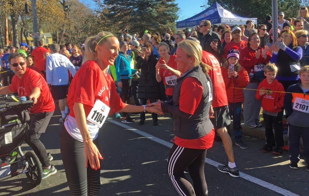 Shalane Flanagan greets finishers at the Back The Track 5K in Marblehead, Mass. (Alex Ashlock/Here & Now)
