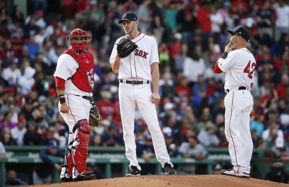 Boston Red Sox's Chris Sale, center, waits on the mound for a visit from pitching coach Carl Willis with Sandy Leon, left, and Dustin Pedroia during the third inning of a baseball game against the Tampa Bay Rays in Boston, Saturday, April 15, 2017, in Boston. (AP Photo/Michael Dwyer)