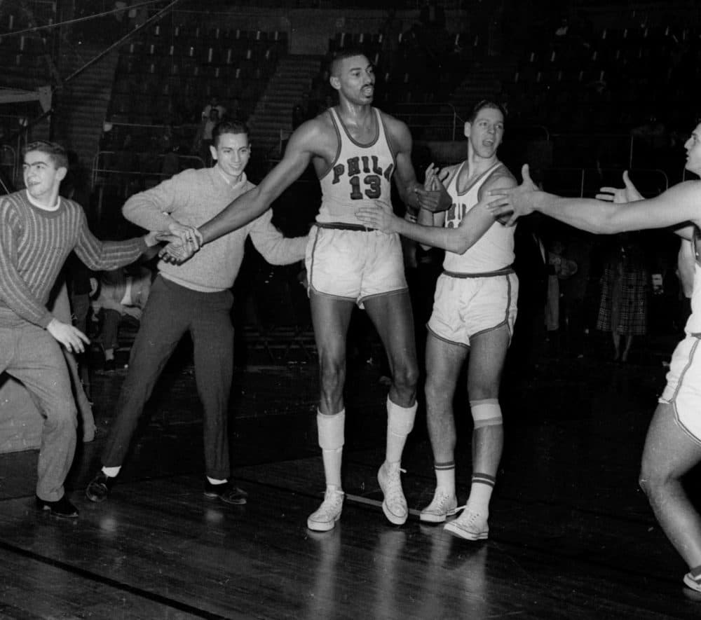 FILE - In this March 2, 1962 file photo, unidentified fans and teammates rush onto court to congratulate Philadelphia Warriors Wilt Chamberlain (13) in Hershey, Pa., after he scored his 100th point in a 169-147 win over the New York Knickerbockers.  For 50 years, Chamberlain's 100-point night has stood as one of sports magic numbers. (AP Photo/Paul Vathis, File)
