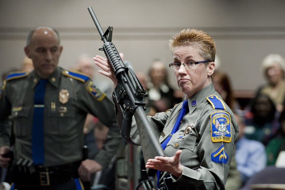 In this Jan. 28, 2013, file photo, firearms training unit Detective Barbara J. Mattson, of the Connecticut State Police, holds up a Bushmaster AR-15 rifle, the same make and model of gun used by Adam Lanza in the Sandy Hook School shooting. (Jessica Hill/AP File)