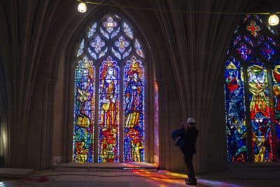 A reporter takes a photograph of a stained glass window at  the Washington National Cathedral. (Cliff Owen/AP)
