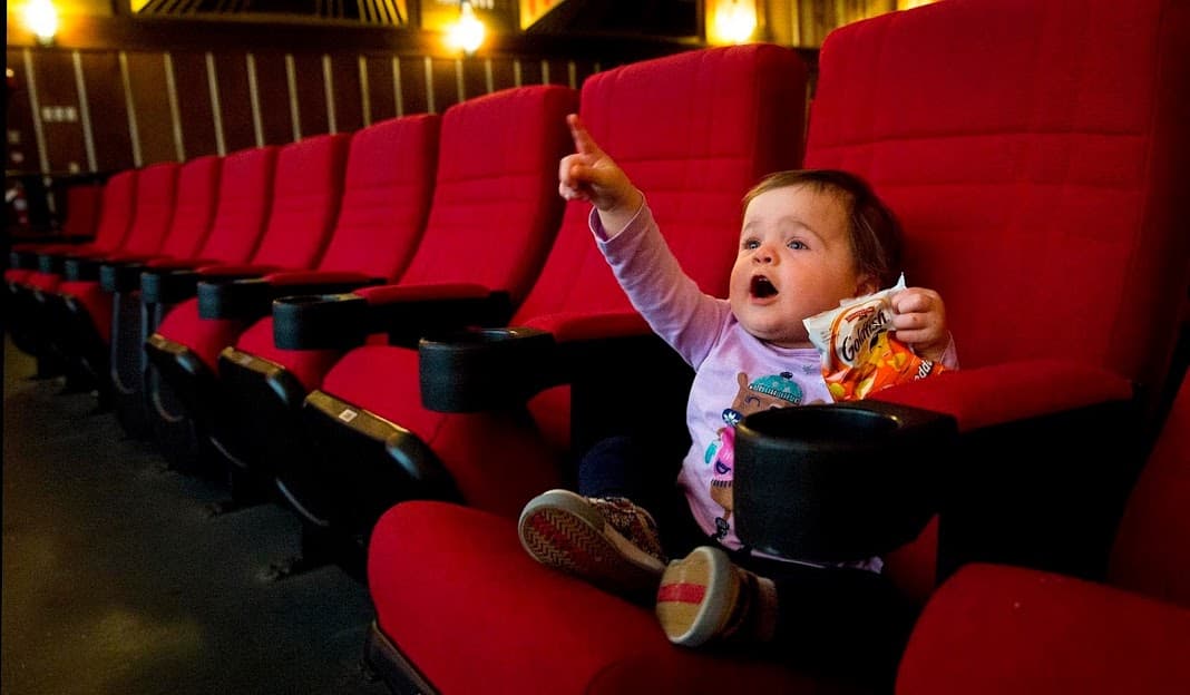 Eighteen-month-old Laura points at the screen of the Coolidge Corner Theatre before a screening of &quot;Faces Places.&quot; (Robin Lubbock/WBUR)
