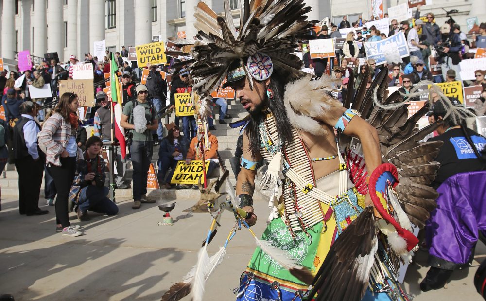 A supporter of the Bears Ears and Grand Staircase-Escalante National Monuments dances with a headdress during a rally Saturday, Dec. 2, 2017, in Salt Lake City. (Rick Bowmer/AP)
