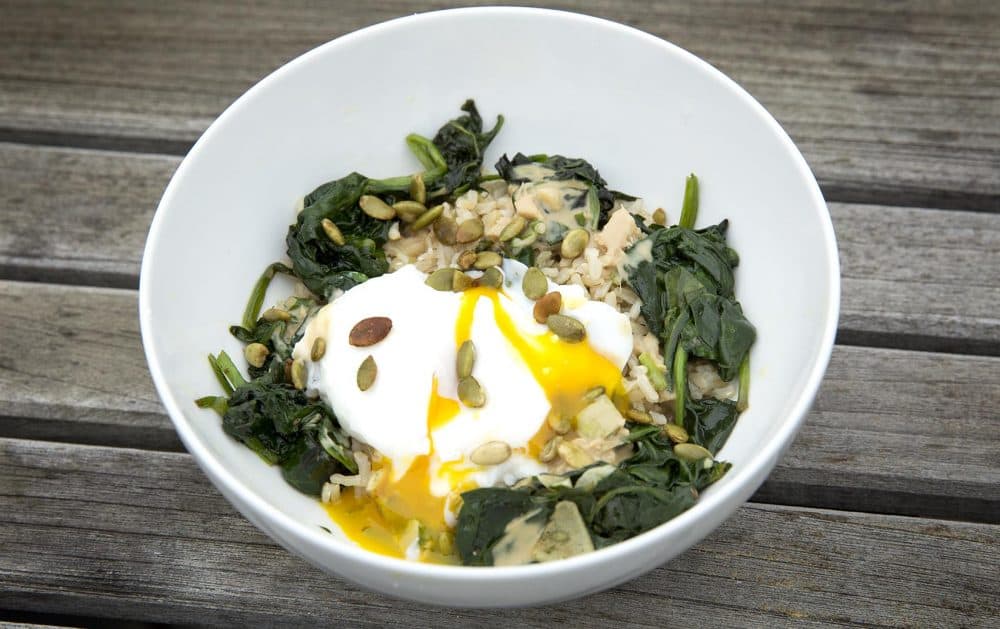 Kathy's healthy rice bowl with sauteed greens, poached egg and pumpkin seeds, with a tahini-ginger sauce. (Robin Lubbock/WBUR)