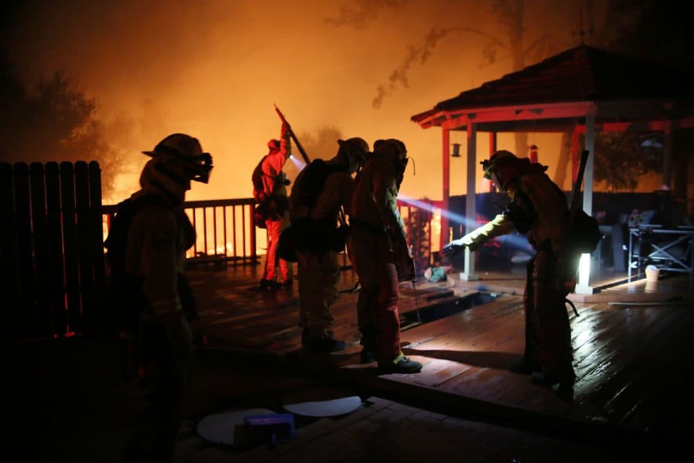 Firefighters work to save a home from an encroaching fire during the Lilac Fire in Bonsall, Calif., on Thursday, Dec. 7, 2017. (Sandy Huffaker/AFP/Getty Images)