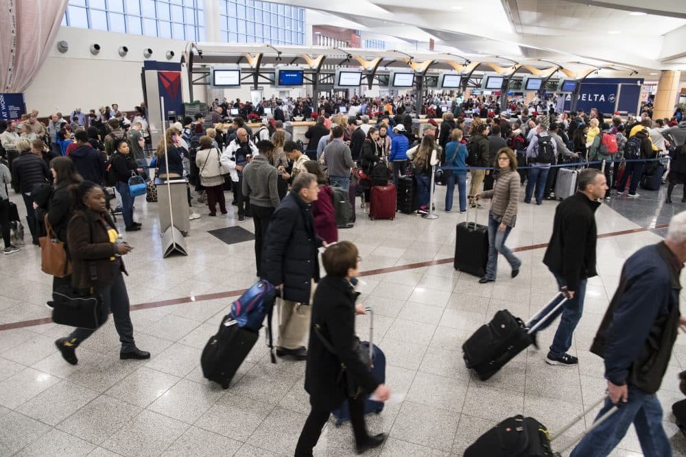 Passengers make their way past long lines at a ticket counter at Hartfield-Jackson Atlanta International Airport, Monday, Dec. 18, 2017, in Atlanta. Power has been restored at the airport after a Sunday blackout caused by a fire stranded thousands of passengers and grounded at least 1,500 flights. (John Amis/AP)
