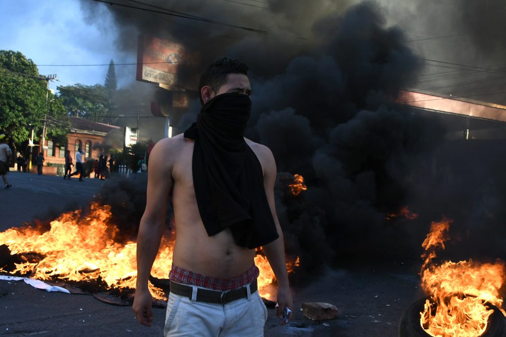 Supporters of the presidential candidate for the Opposition Alliance Against the Dictatorship, Salvador Nasralla, set fire to tires as they protest against the re-election of President Juan Orlando Hernandez in elections marred by suspicions of fraud, outside the U.S. Embassy in Tegucigalpa on Dec. 21, 2017. (Orlando Sierra/AFP/Getty Images)