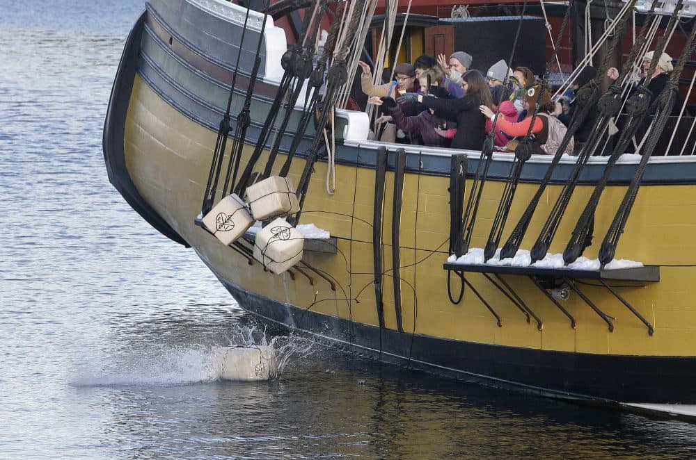 In this Monday, Dec. 11, 2017 photo, visitors to the Boston Tea Party Museum throw replicas of historic tea containers into Boston Harbor from aboard a replica of the vessel Beaver, in Boston. The museum is encouraging Americans to send unused tea leaves to toss into Boston Harbor as part of the Saturday, Dec. 16, 2017, annual re-enactment of the historic act of defiance that led to the Revolutionary War. (Steven Senne/AP)