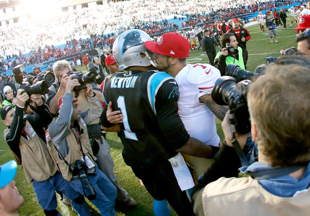 Cam Newton of the Carolina Panthers and former 49ers quarterback Colin Kaepernick speak after their 2014 NFC Divisional Playoff Game. If Kaepernick becomes part owner of the Panthers, he'll be Newton's boss. (Kevin C. Cox/Getty Images)