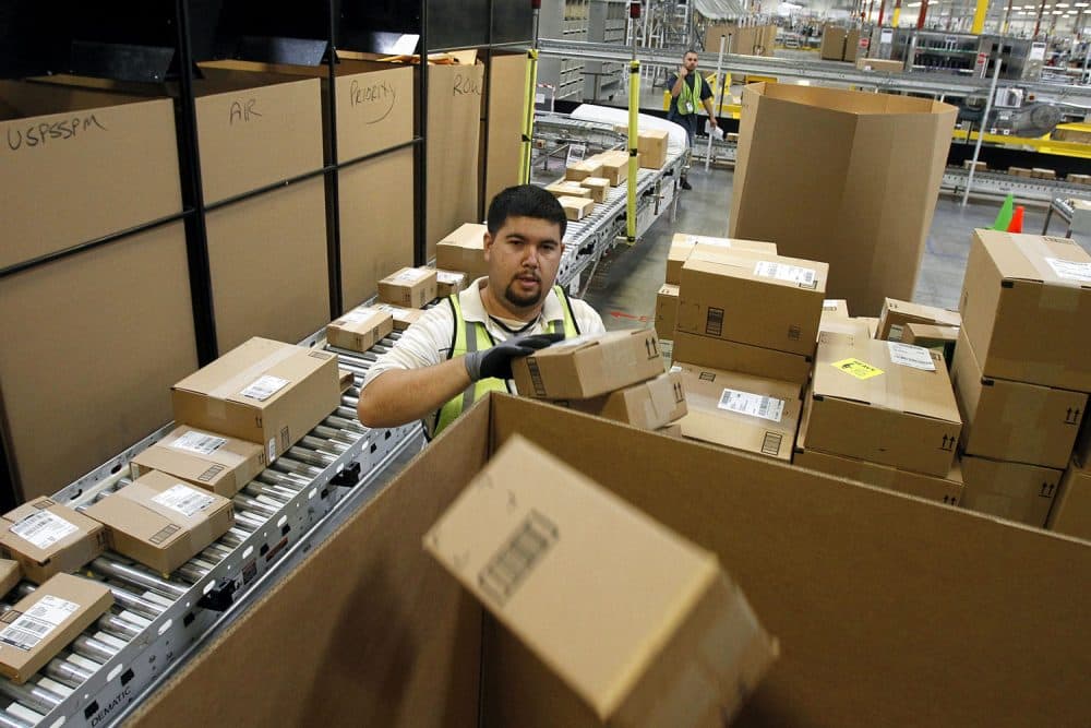 FILE - In this Nov. 11, 2010 file photo, Ricardo Sandoval sorts packages at an Amazon.com fulfillment center, in Phoenix. Merchants are working hard to make same-day delivery a reality, particularly in major cities, from Amazon testing deliveries via taxis to everyone from Target to Google expanding their same-day delivery services. (AP Photo/Ross D. Franklin, File)