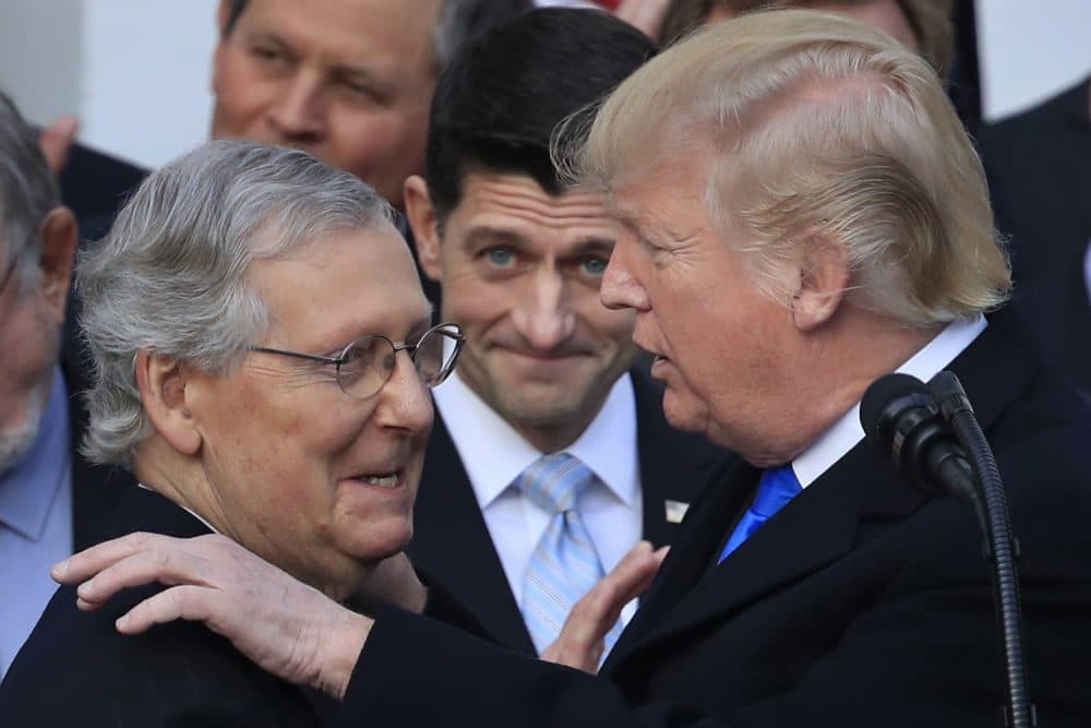 President Donald Trump congratulates Senate Majority Leader Mitch McConnell of Ky., while House Speaker Paul Ryan of Wis., watches to acknowledge the final passage of tax overhaul legislation by Congress at the White House in Washington, Wednesday, Dec. 20, 2017. (AP Photo/Manuel Balce Ceneta)