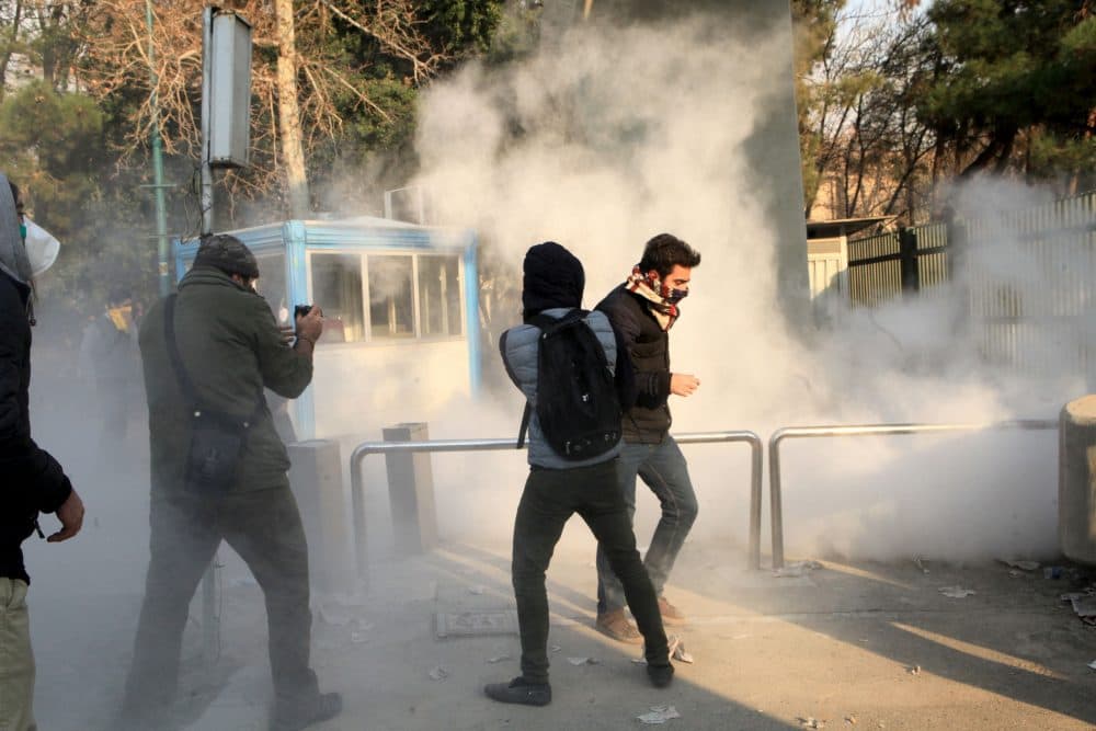 Iranian students run for cover from tear gas at the University of Tehran during a demonstration driven by anger over economic problems, in the capital Tehran on Dec. 30, 2017. (STR/AFP/Getty Images)