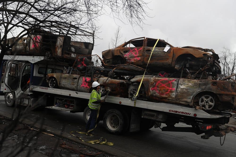 A worker secures burned-out cars onto a truck in the Coffey Park neighborhood on Nov. 13, 2017 in Santa Rosa, Calif. (Justin Sullivan/Getty Images)