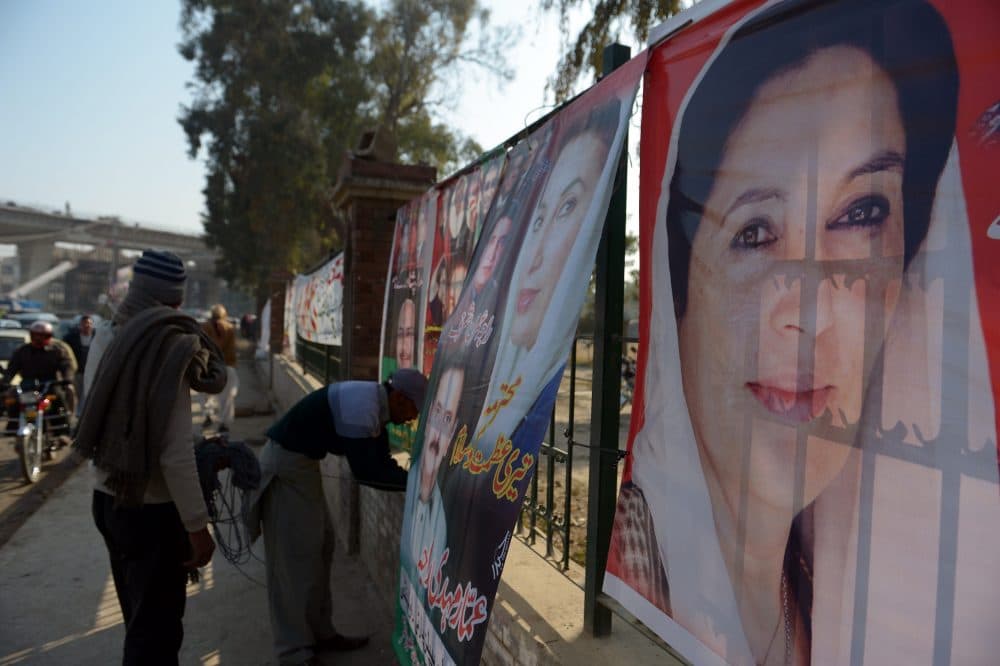 A supporter of the Pakistan Peoples Party (PPP) hangs a poster of slain former Prime Minister Benazir Bhutto at her assassination site in Rawalpindi on Dece. 26, 2014, on the seventh anniversary of her death. (Farooq Naeem/AFP/Getty Images)