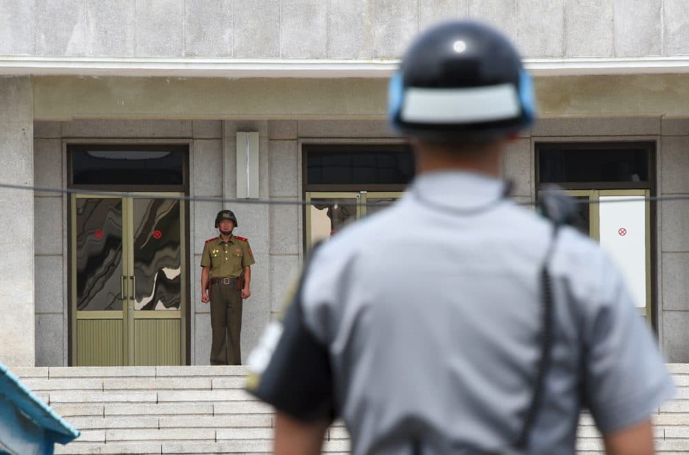 A North Korean soldier (left) looks at the south side as a South Korean soldier (right) stands guard during a press tour to the truce village of Panmunjom in the Demilitarized Zone on July 19, 2017. (Jung Yeon-Je/AFP/Getty Images)