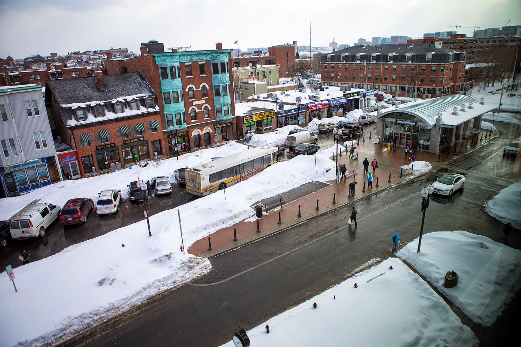 Between parked cars and snow banks, it's a tight squeeze for an MBTA bus in snow-filled Maverick Square in 2015. (Jesse Costa/WBUR)