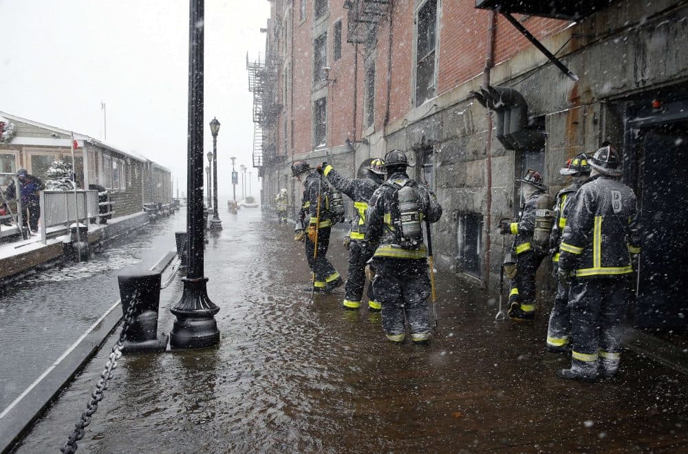 Boston firefighters work at the scene of flooding from Boston Harbor on Long Wharf in Boston, Jan. 4, 2018. (Michael Dwyer/AP)