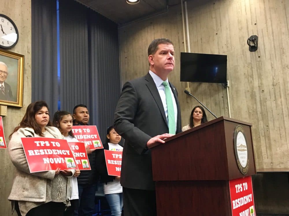 Boston Mayor Marty Walsh, standing with TPS holders, spoke at a press conference Wednesday addressing the Trump administration's decision to end TPS for immigrants from El Salvador. (Shannon Dooling/WBUR)