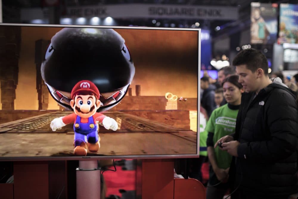 Visitors play Mario Odyssey video game at the Nintendo stand at the Paris Games Week in Paris, Friday, Nov. 3, 2017. (Kamil Zihnioglu/AP)