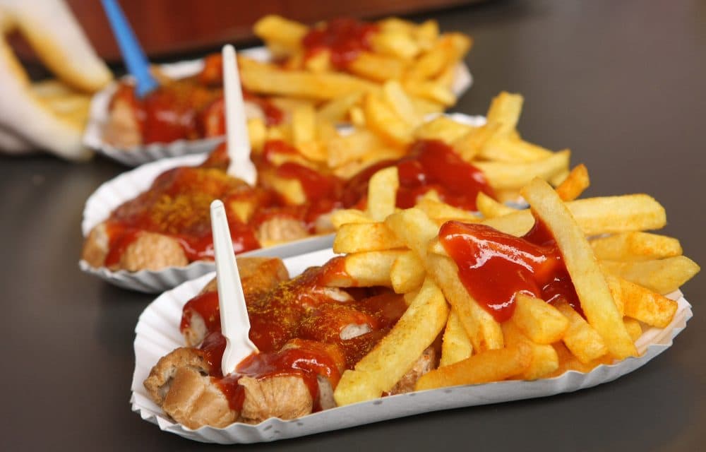 An employee prepares plates of currywurst with french fries at Konnopke's currywurst stand on July 14, 2012 in Berlin, Germany. Currywurst, originally founded in post-war Berlin by Herta Heuwer, is Berlin's answer to fast food and is sold at specialized stands across the city and the rest of Germany. (Adam Berry/Getty Images)