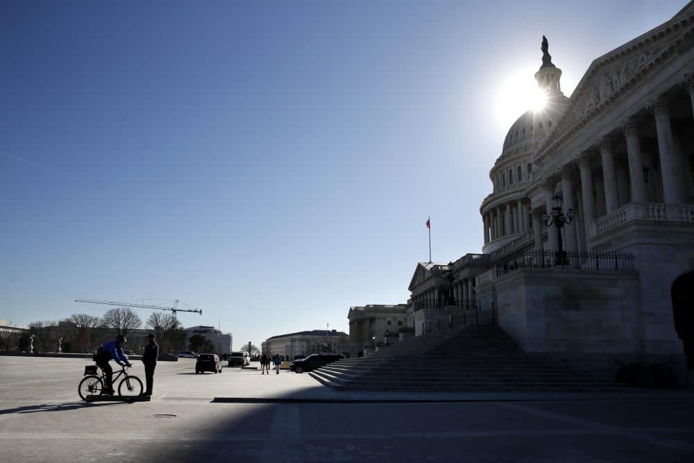 The sun casts a shadow over the Capitol on Friday as a bitterly-divided Congress hurtles toward a government shutdown this weekend. (Jacquelyn Martin/AP)