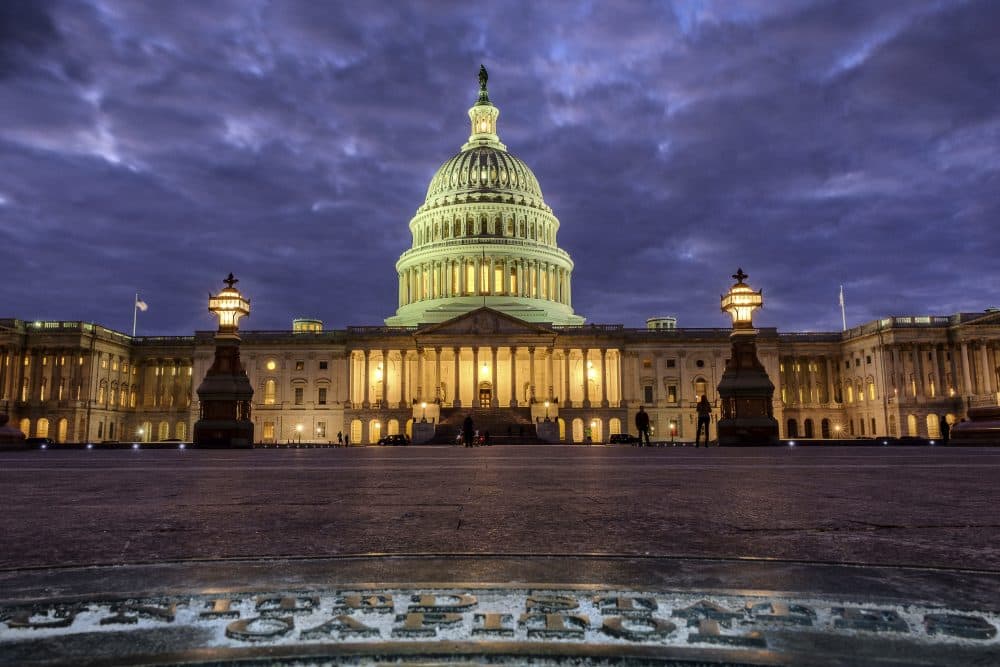 In this Jan. 21, 2018, photo, lights shine inside the U.S. Capitol Building as night falls in Washington. (J. David Ake/AP)