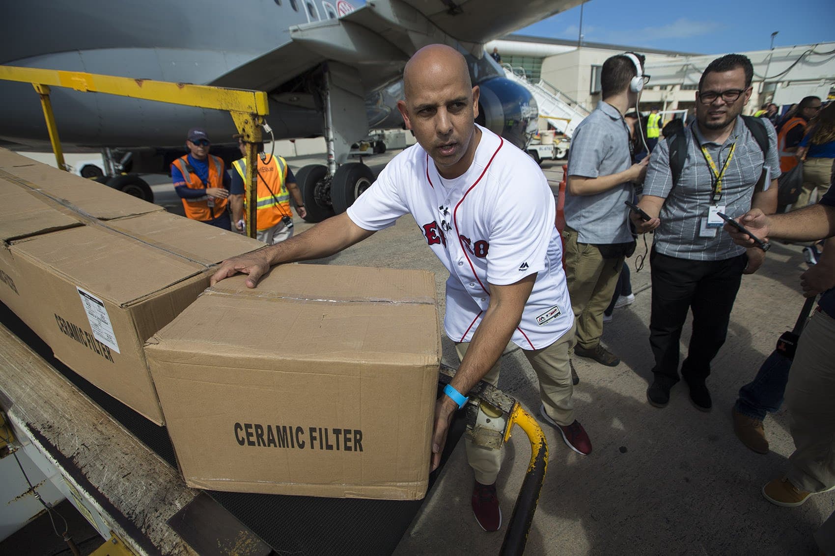 Red Sox manager Alex Cora picks up a box of supplies which will be delivered to his hometown of Caguas, in Puerto Rico. (Jesse Costa/WBUR)