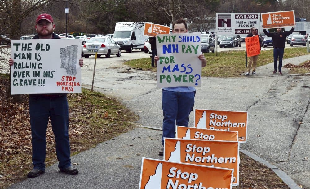 Nick Paul, left, of Concord, and Tim Madsen, of Manchester, protest with three others from the group Protect the Granite State outside a hearing by the state's Site Evaluation Committee for the Northern Pass project in 2017. Massachusetts announced Wednesday it would not sign onto the project. (Michael Casey/AP)
