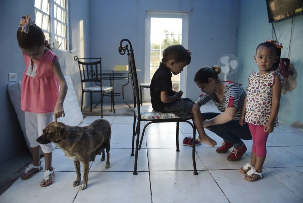 In this Dec. 22, 2017 photo, Wilmarie González Rivera prepares her children to attend a Christmas party at their school in Morovis, Puerto Rico. (Carlos Giusti/AP)