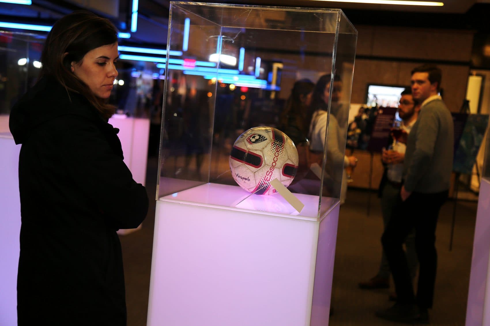 A visitor looks at a soccer ball in the &quot;Museum without a Home&quot; exhibit. (Courtesy Lisa Aimola/Oxfam)