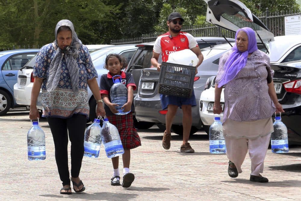People carry water collected from a natural spring in Cape Town, South Africa, Monday, Jan 22, 2018 as the city suffers from one of the worst droughts in recent history. Officials are looking to combat the drought, saying it was looking more likely that it will have to turn off most taps on &quot;Day Zero,&quot; or April 21 stating that 60 percent of residents are &quot;callously&quot; using more than the current limit and that the city will fine households that use too much water. (AP Photo/Anwa Essop)