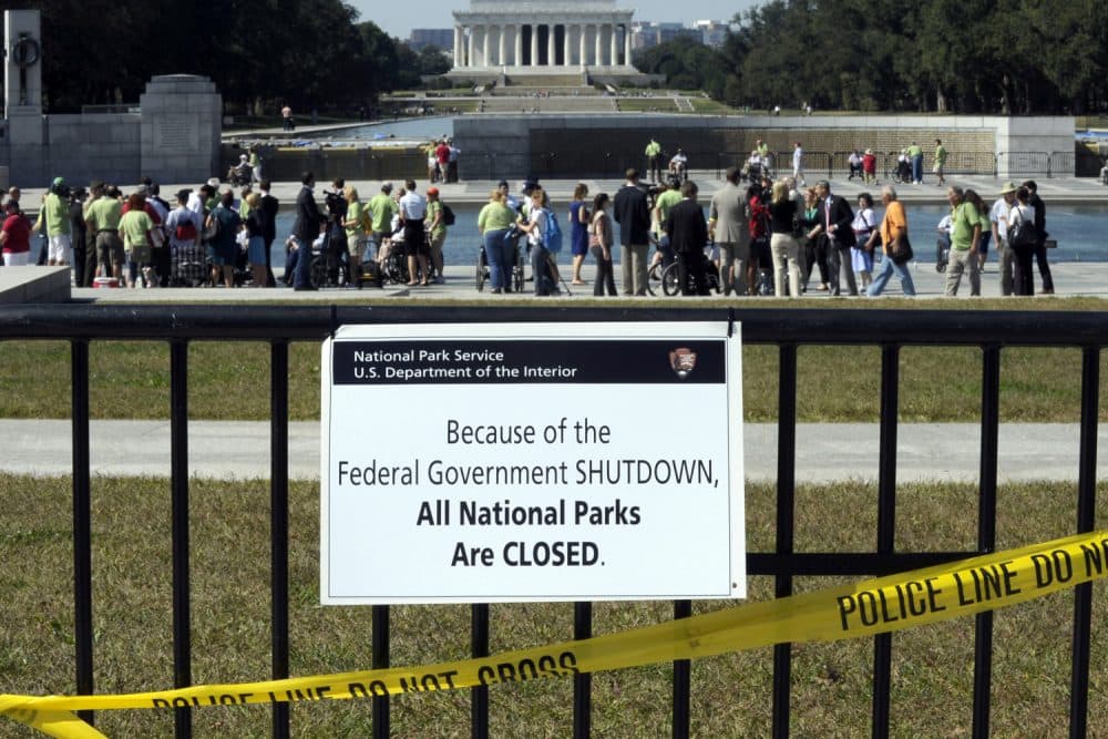 In this Oct. 2, 2013 file photo, despite signs stating that the national parks are closed, people visit the World War II Memorial in Washington. (Susan Walsh/AP)