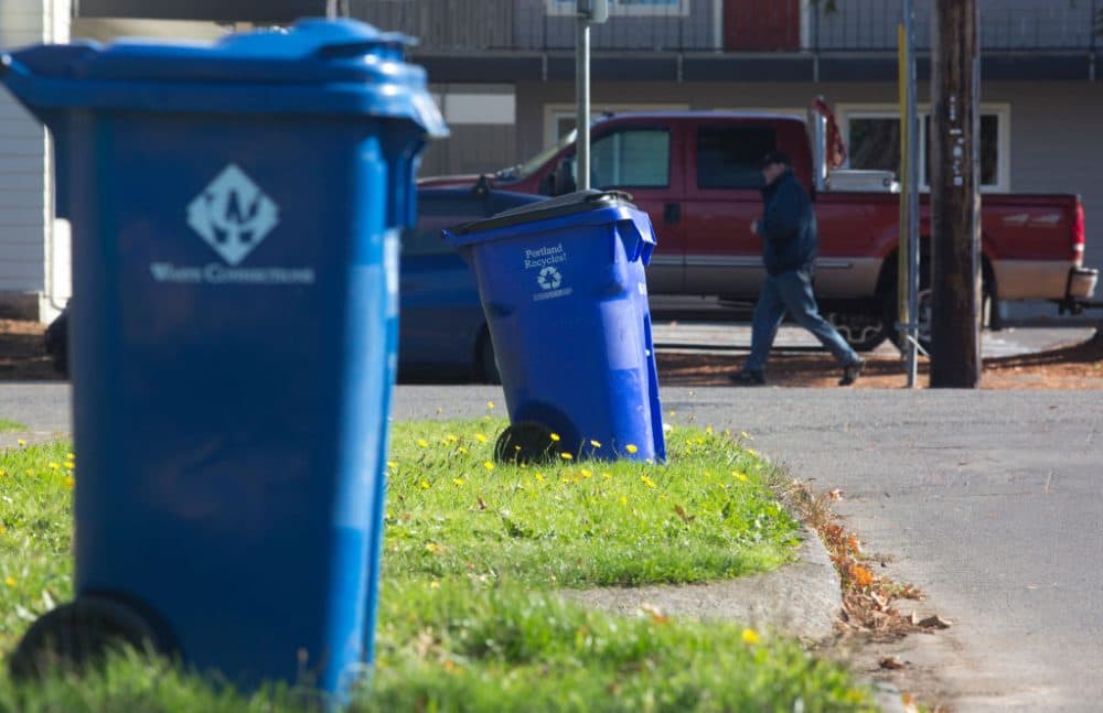Blue recycling bins are seen on a residential street, Oct. 30, 2017 in Portland, Oregon. China is sharply restricting imports on recycled materials, and the impact will be felt across the Pacific Northwest. (Natalie Behring/Getty Images)