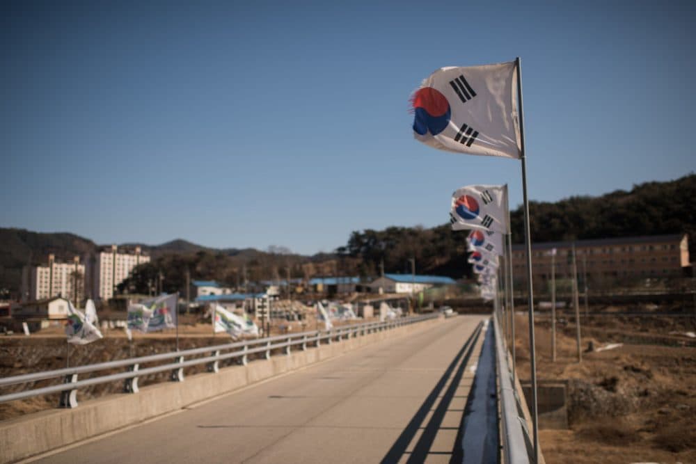 South Korean flags line a road bridge in the village of Girin-myeon, near the Inje Speedium resort complex where a delegation of North Korean cheerleaders attending the 2018 Pyeongchang Winter Olympic Games are due to stay, on Feb. 5, 2018. (Ed Jones/AFP/Getty Images)