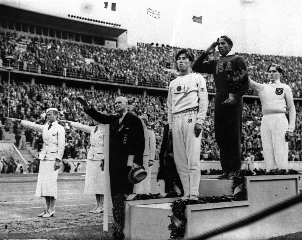 In this Aug. 11, 1936 file photo, Olympic broad jump medalists salute during the medals ceremony at the Summer Olympics in Berlin. From left on podium are: bronze medalist Jajima of Japan, gold medalist Jesse Owens of the United States and silver medalist Lutz Long of Germany. (AP Photo)